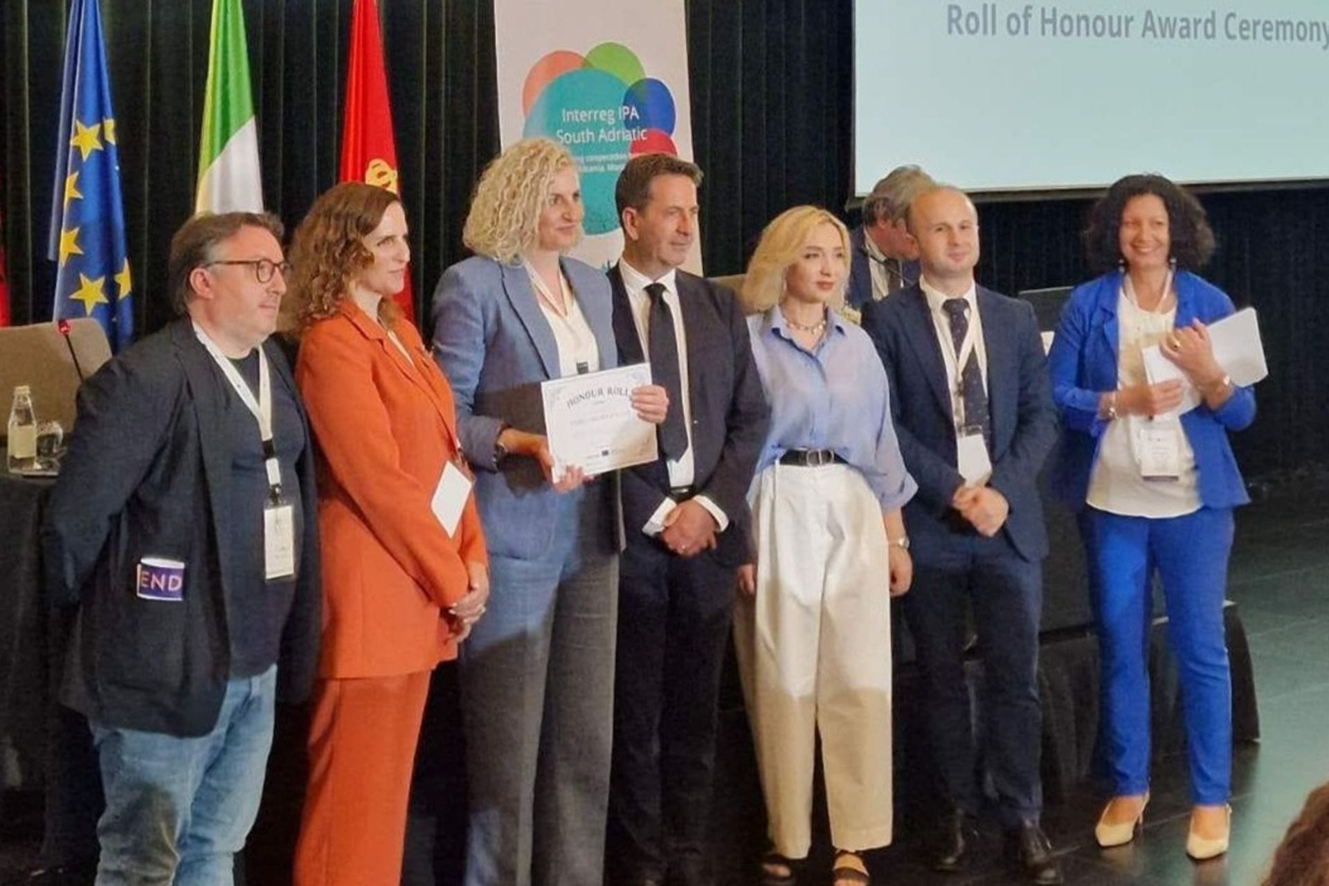 Na zvaničnoj ceremoniji održanoj 18. juna 2025. u Tirani, Ministarstvo socijalnog staranja, brige o porodici i demografije predstavljeno je kao vodeći i punopravan partner u okviru dva značajna projekta Interreg IPA programa Južni Jadran 2021–2027, čime potvrđuje svoju ulogu u jačanju regionalne saradnje i promociji evropskih vrijednosti.

Na događaju posvećenom promociji prekogranične saradnje zemalja regiona Južnog Jadrana, Ministarstvo socijalnog staranja, brige o porodici i demografije preuzelo je vodeću ulogu u realizaciji projekta Religious R.O.A.D., koji ima za cilj očuvanje zajedničkog kulturnog nasljeđa i promociju međureligijskog dijaloga. Projekat takođe podstiče interkulturno razumijevanje i doprinosi jačanju društvene kohezije.
Pored toga, Ministarstvo učestvuje i kao punopravan partner u projektu GOAL HEALTH, usmjerenom na unapređenje integrisanih zdravstvenih i socijalnih usluga, posebno za osjetljive društvene grupe. Kroz razmjenu dobrih praksi s institucijama iz drugih zemalja, projekat ima za cilj razvoj inovativnih rješenja za inkluzivniju i otporniju zajednicu.
Ceremoniju su otvorili Claudio Polignano, rukovodilac Upravljačkog tijela Interreg IPA programa za Južni Jadran, i Gilles Kittel iz Generalnog direktorata za regionalnu i urbanu politiku Evropske komisije. U svojim obraćanjima istakli su važnost ovakvih projekata za jačanje povezanosti i otpornosti lokalnih zajednica u regionu.
Ministarstvo su na ceremoniji predstavljale Granica Simićević, načelnica Odjeljenja za programiranje i implementaciju EU fondova, i Jelena Banašević, službenica za programiranje. Nakon zvaničnih govora, organizovana je radionica za vodeće partnere na kojoj su predstavljene procedure i obaveze vezane za implementaciju projekata.
Ministarstvo je potvrdilo svoju posvećenost sprovođenju projekata koji promovišu evropske vrijednosti i doprinose razvoju socijalnih politika i očuvanju kulturnog identiteta regiona.